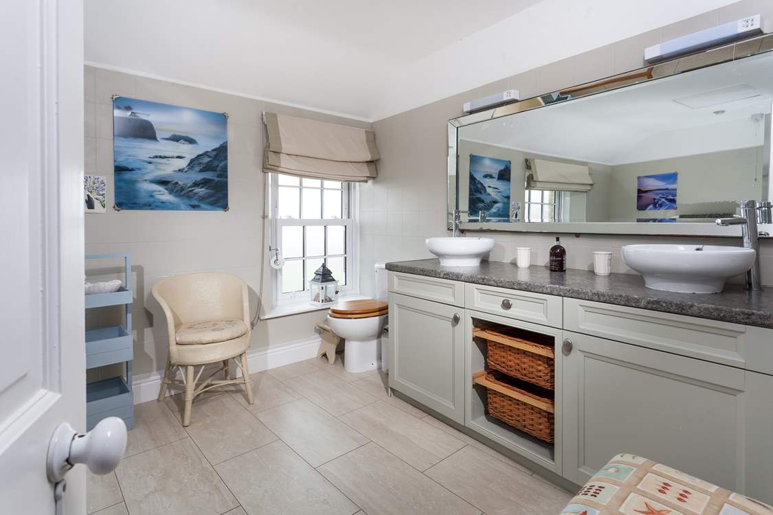 The large and stylish bathroom with double sinks at one end.