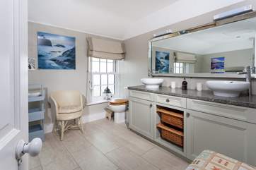The large and stylish bathroom with double sinks at one end.