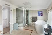 The family bathroom is incredibly spacious with a large shower cubicle. Sitting on a raised platform at one end of the room, the large bath is big enough for two.