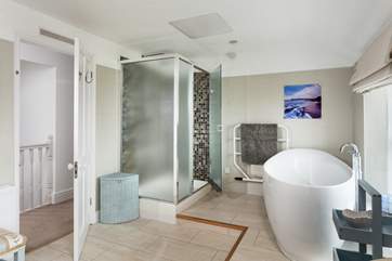 The family bathroom is incredibly spacious with a large shower cubicle and bath big enough for two sitting on the raised bathing platform at one end of the room.