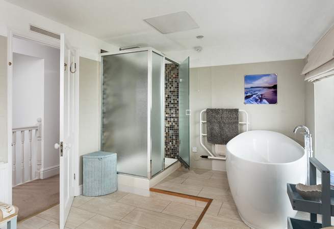 The family bathroom is incredibly spacious with a large shower cubicle and bath big enough for two sitting on the raised bathing platform at one end of the room.