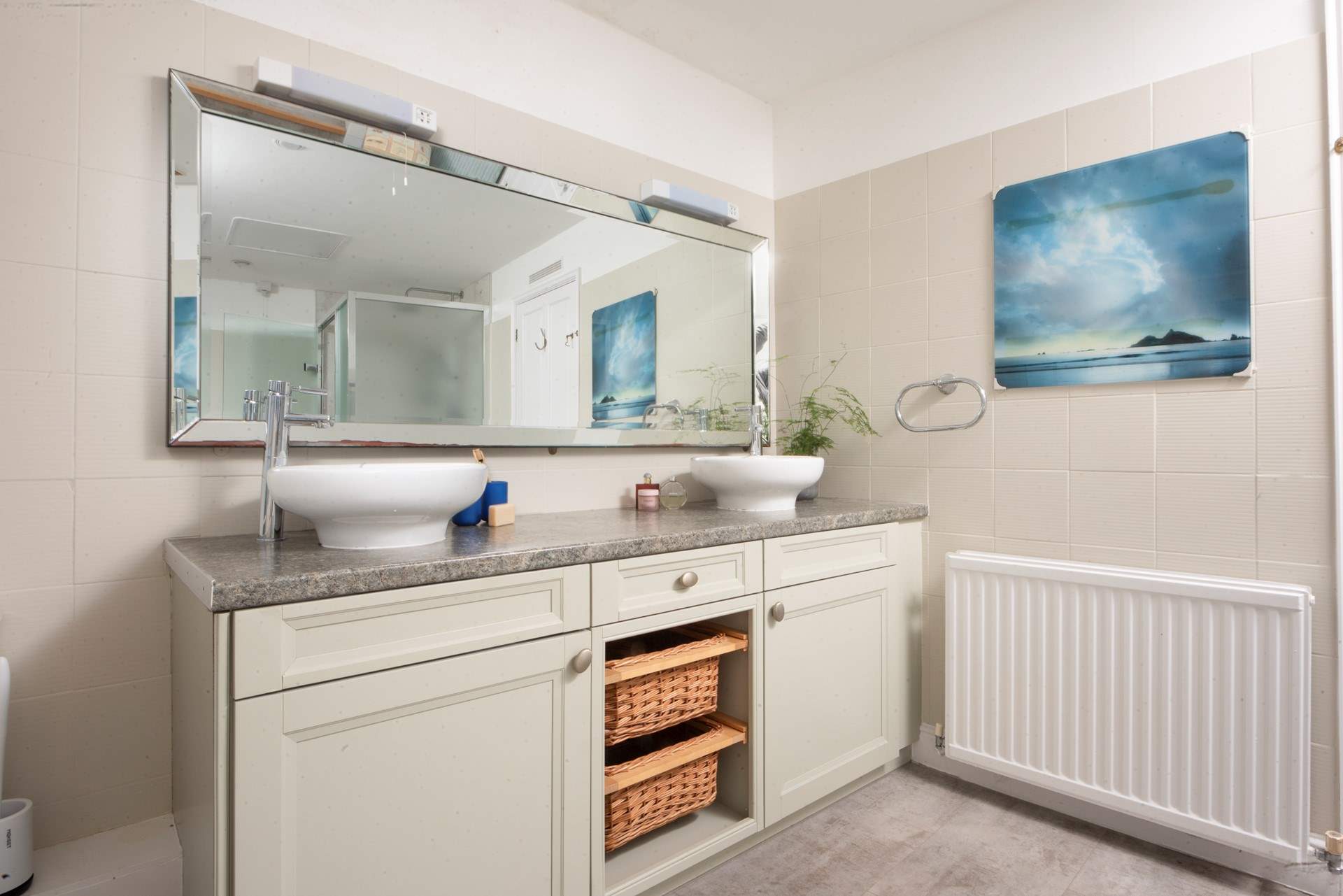 The stylish family bathroom has a double basin.