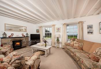 The sitting-room has beautiful beams, sea views and a wood-burner.