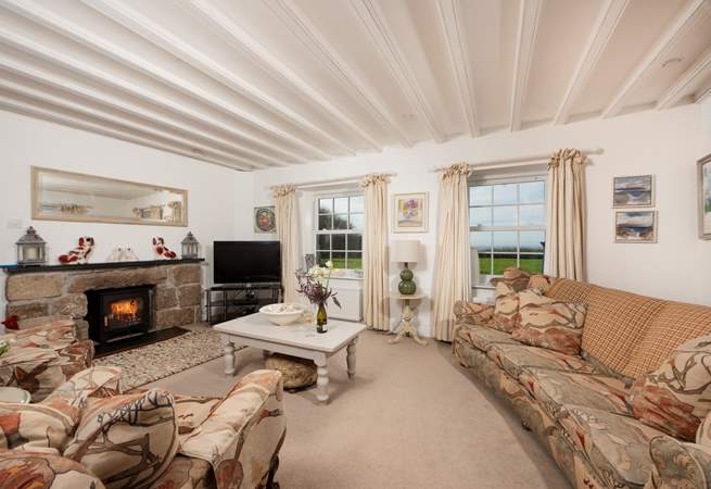 The sitting-room has beautiful beams, sea views and a wood-burner.