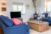 The living-area has a cosy wood-burner and sea views over to Nare Head.