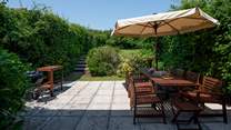Step out of the house onto this fabulous patio and large garden which stretches out beyond.