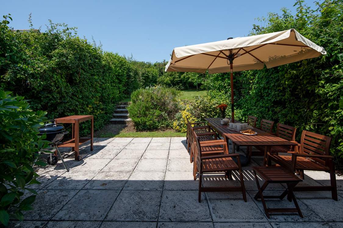 Step out of the house onto this fabulous patio and large garden which stretches out beyond.