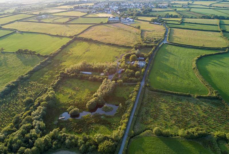 An ariel view of the lake and woods with the village of Woolsery in the distance. Straw Cottage is to the left of the white house in the centre of the photograph (the owners' home) and has its own large garden.