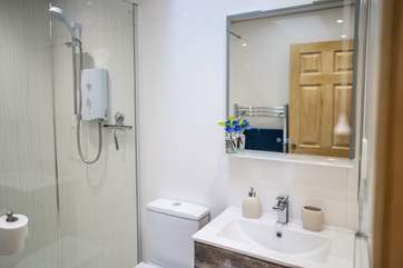 The bathroom has a large walk-in electric shower and benefits from a heated towel rail.