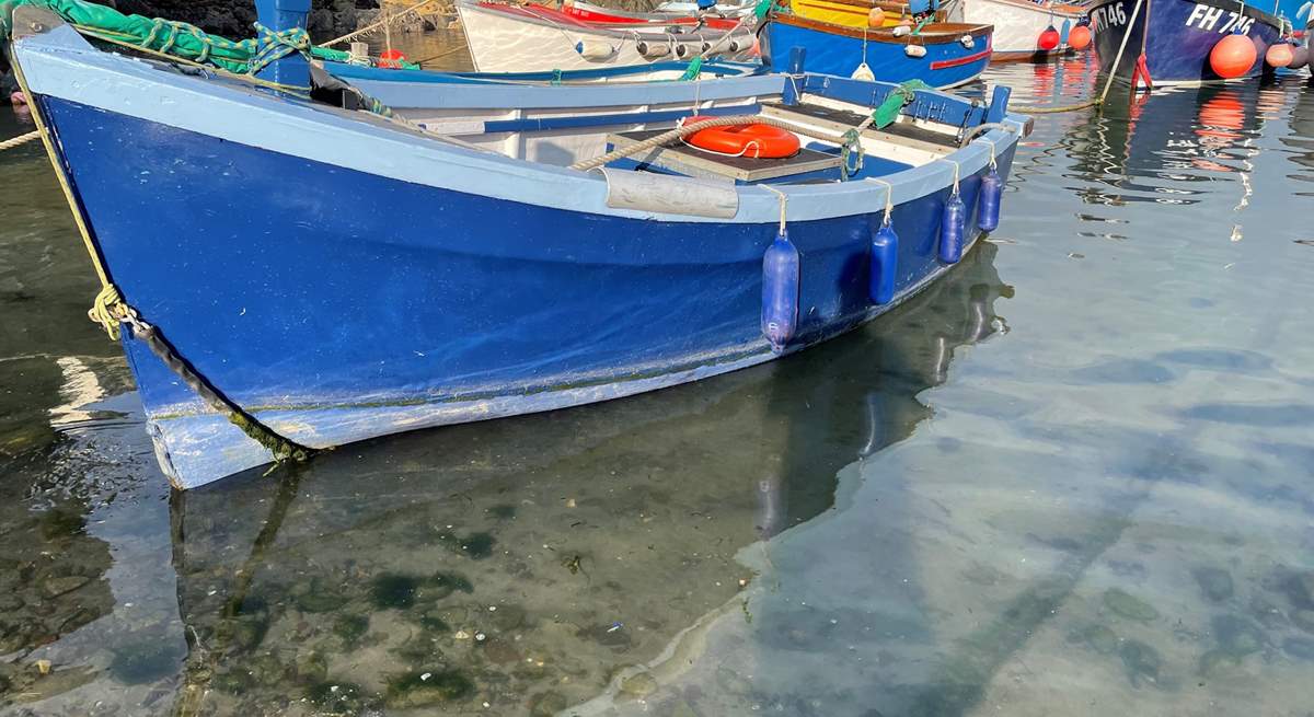 Pretty fishing boats rest in the harbour in Coverack. 