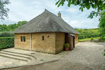 This view of the cottage shows the large parking area and garden beyond.