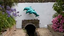 Just look for the dolphins and you know you're home. Please note, the stream running in front of the property is fully fenced off and secure.
