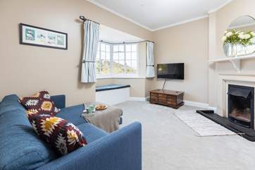 The snug has a smart tv and an open fire place.