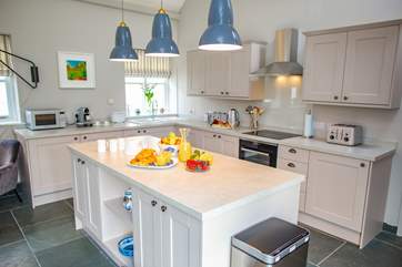 The modern bright kitchen sits within the open plan central living area.