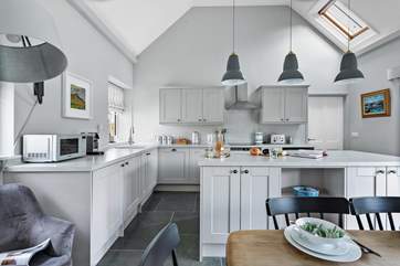The modern bright kitchen sits at the end of the space.