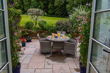 The dining patio benefits from luxury outside furniture, accessed through the patio doors. Please note behind the shrubs will be a fence as this is the owners' lawn.