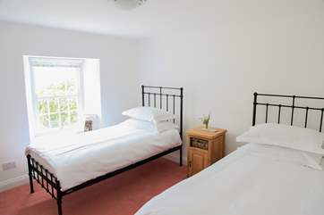 Bedroom 3 has twin beds and overlooks the garden, with the sea in the distance.