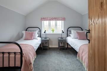This very pretty twin bedroom looks out over the garden.