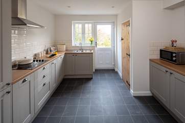 The kitchen is excellently equipped and has a door out to your private patio. The downstairs WC is tucked behind the wooden door on the right.