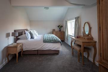 What a gorgeous main bedroom; complete with pretty garden views.