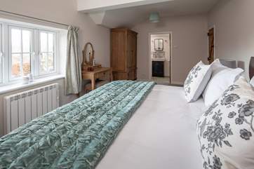 The beautiful main bedroom has pretty garden views.
