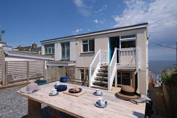 There is a sheltered rear terrace with stairs that lead into the kitchen.