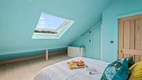 Light and airy bedroom 5 boasts views over Teignmouth back beach and the delightful array of beach huts.