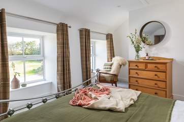 This dual-aspect bedroom has views over the garden.
