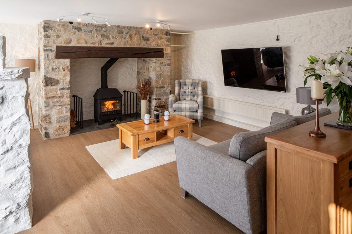 Beautiful sitting-area with glowing wood-burner.