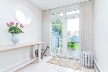 The light and airy sitting-room leads out onto the garden area.