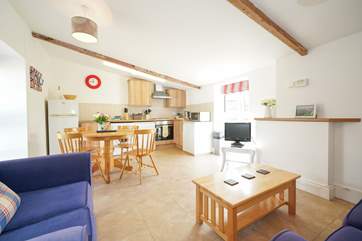 The open plan living-room with kitchen and dining areas is light and airy.