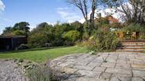 The patio with steps leading up to the decking where you can sit by the pond and admire the view.