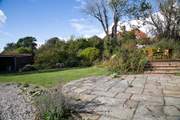 The patio with steps leading up to the decking where you can sit by the pond and admire the view.