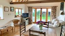 The spacious open plan living-room has exposed beams.