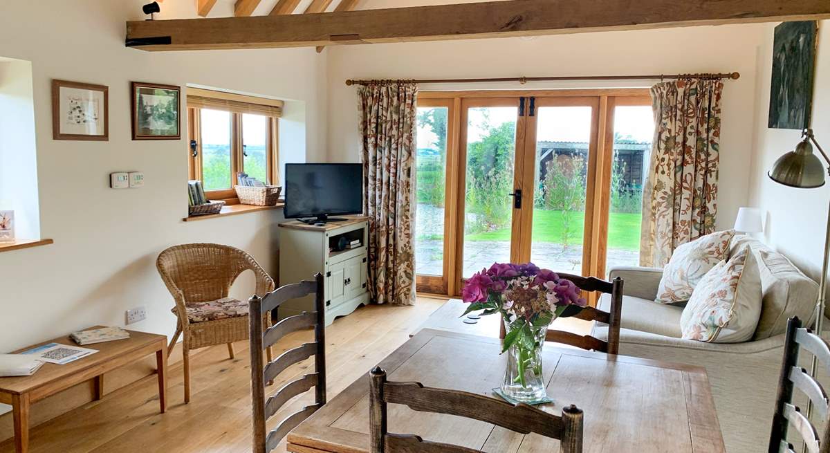 The spacious open plan living-room has exposed beams.