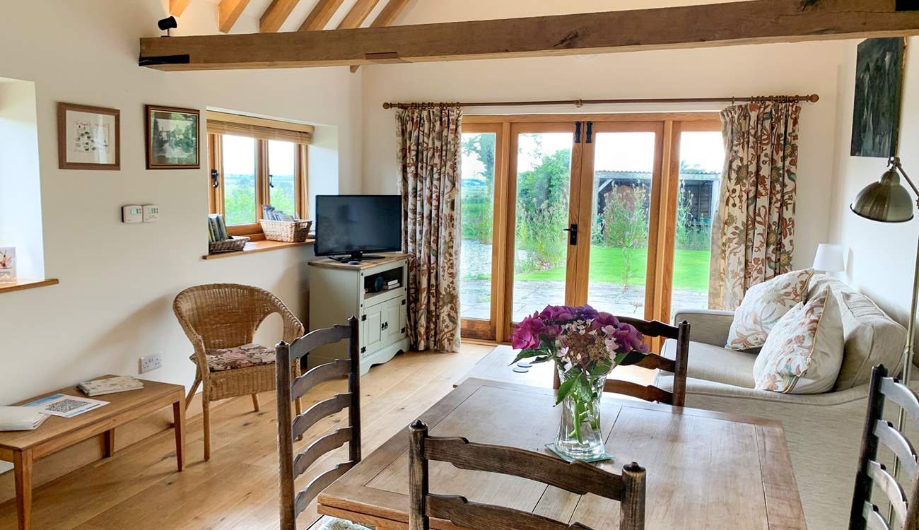 The spacious open plan living-room has exposed beams.