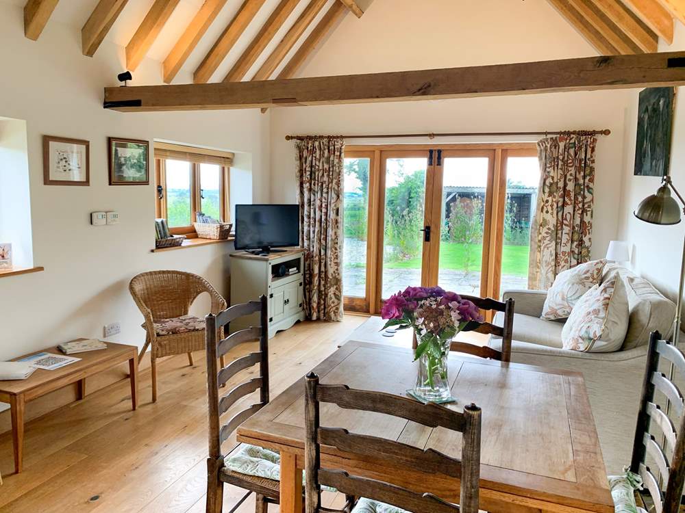 The spacious open plan living-room has exposed beams.