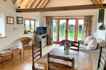 The spacious open plan living-room has exposed beams.