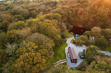 Here you can see the Lodge, with the laundry-room/outhouse to the right and the BBQ hut and lake in front.