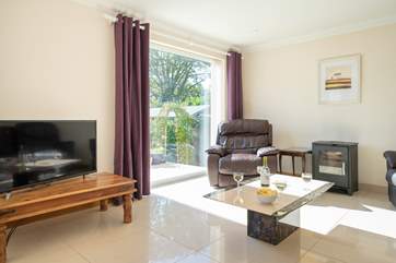 The comfortable sitting/dining-room with views across the garden. Please note the wood-burner is not for guests' use.