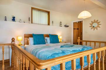 The bed is located on a mezzanine floor at the back of The Hideaway.