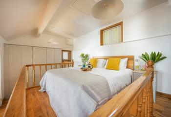 The bed is located on a mezzanine floor at the back of The Hideaway.