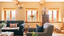 A beautiful sitting-room with plenty of comfortable seating, natural light and original features.