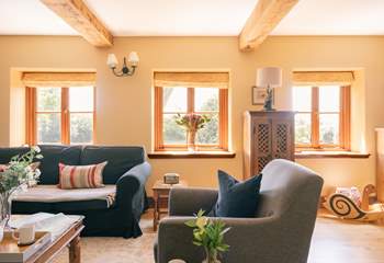 A beautiful sitting room with plenty of comfortable seating, natural light and original features