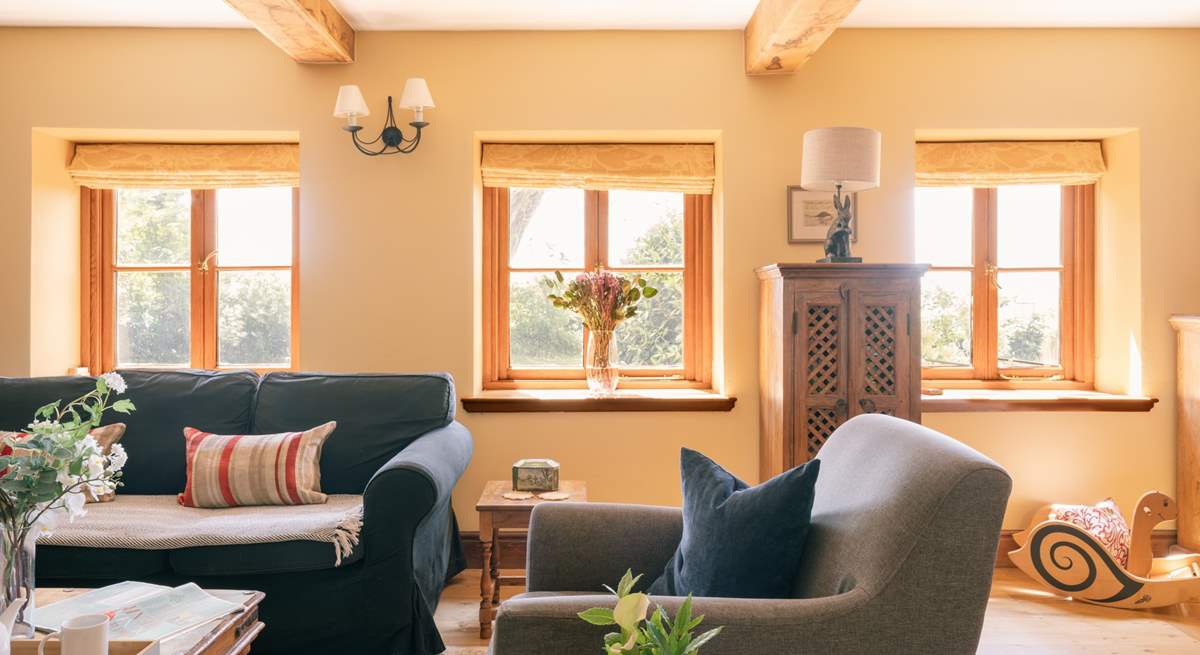 A beautiful sitting room with plenty of comfortable seating, natural light and original features