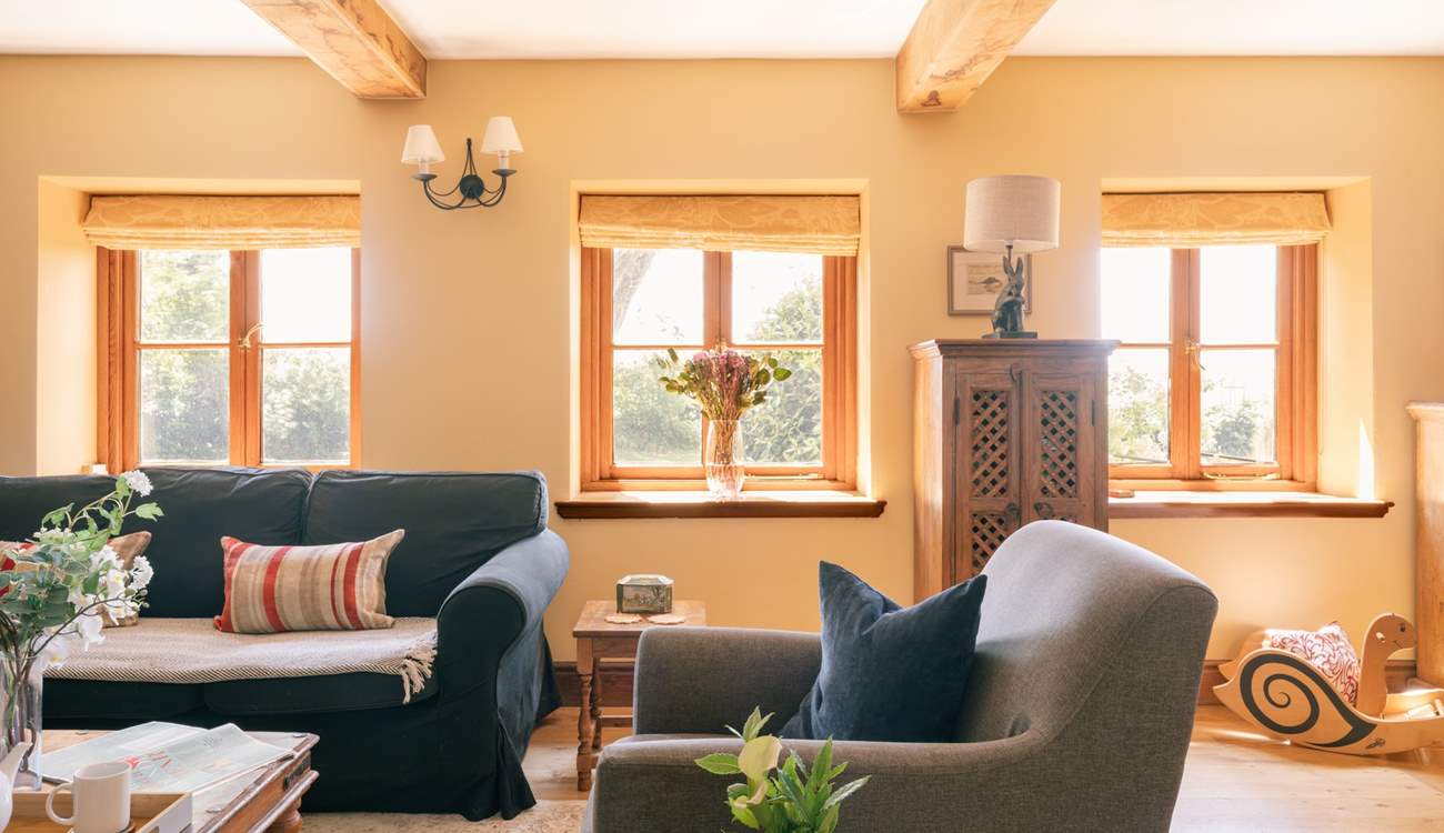 A beautiful sitting room with plenty of comfortable seating, natural light and original features