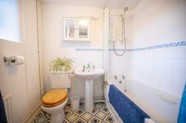 The bathroom is on the ground floor, off the hallway, by the front door and benefits from a bath and an electric shower.