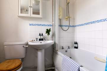 The bathroom is on the ground floor, off the hallway, by the front door and benefits from a bath and an electric shower.