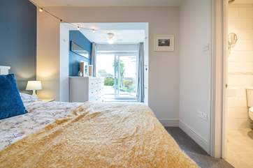 One of the five spacious bedrooms, this room has an en suite shower-room and doors out to the ground floor patio.