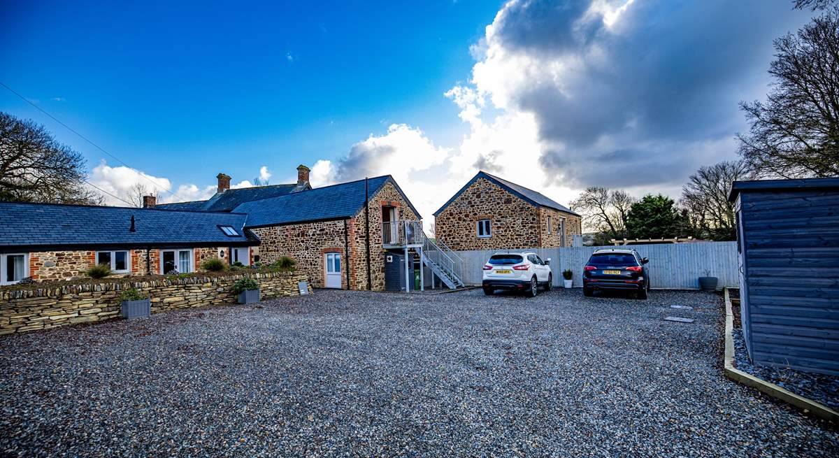 The Dairy has one designated parking space (white car) to the right of the stairs with additional parking to the back of the barn.